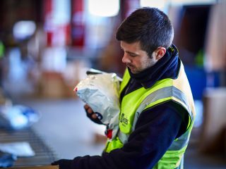 Menzies Pick and Pack parcel worker in a high vis vest