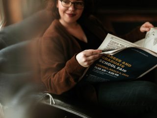 Female with glasses reading newspaper